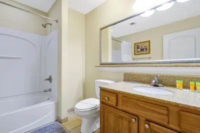 a bathroom with a sink and a toilet and a mirror at Living the Disney Dream! Lake View Luxury Condo in Orlando