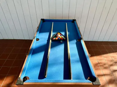 a blue pool table with two cue sticks on it at Orlando Luxe Retreat with Private Pool in Orlando