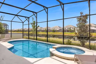 a swimming pool with a view of a house at Beautiful and cozy at Veranda Palms in Kissimmee