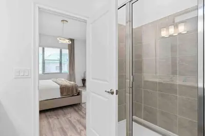 a bathroom with a walk in shower next to a bedroom at SUPER RITZY - 9BDRs-9BAs w Theme Rooms LOFT & POOL in Orlando