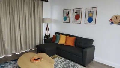 a living room with a black couch and a table at Orlando 12th Floor - 5 min Disney in Orlando