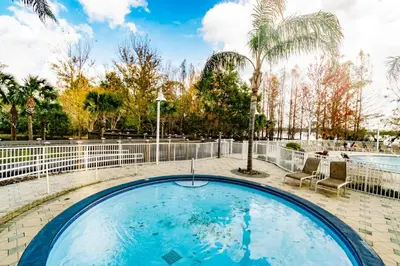 a large swimming pool with a fence and trees at Orlando Blue Heron 1 Mile From Disney 2nd floor in Orlando