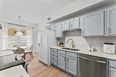 a kitchen with white cabinets and a white refrigerator at SUPER BOHO - LAKE TOHO FISHiNG WATER FRONTs in Kissimmee