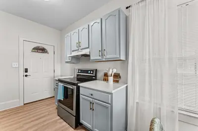 a kitchen with white cabinets and a stove top oven at SUPER BOHO - LAKE TOHO FISHiNG WATER FRONTs in Kissimmee
