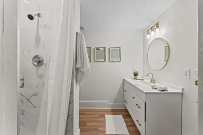 a white bathroom with a shower and a sink at SUPER BOHO - LAKE TOHO FISHiNG WATER FRONTs in Kissimmee