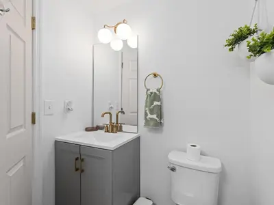 a bathroom with a sink and a toilet and a mirror at SUPER BOHO- At LAKE TOHO's WATER SLEEPs 6 in Kissimmee