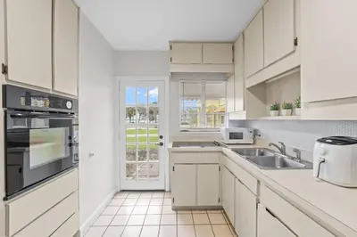 a white kitchen with a sink and a window at SUPER BOHO - At Lake Toho Fishing VINTaGE VIBEs in Kissimmee