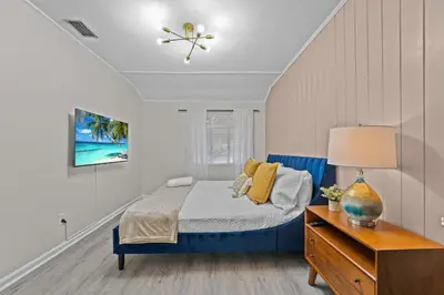 a bedroom with a blue bed and a dresser at SUPER BOHO - Lake Toho Timeless Charm in Kissimmee