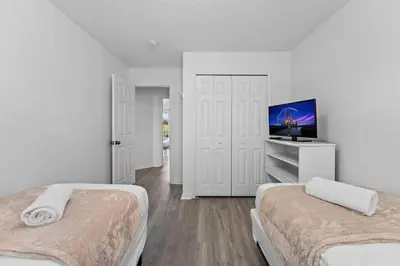 a white room with two beds and a flat screen tv at SUPER YES - MANY AMENITIEs RELAX GYM COURTs in Kissimmee