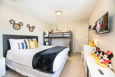 a bedroom with a bed and a bunk bed at SUPER CHIC - 4 Bedroom TOWNHOME IN DISNEY AREA in Kissimmee