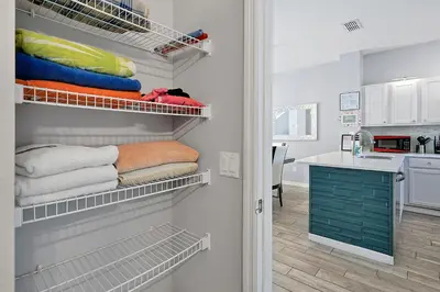a room with a closet with towels and a kitchen at Encantada Resort - Spacious 3-Bedroom Villa with Private Pool Near Disney in Kissimmee