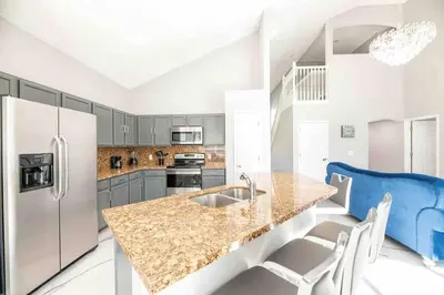 a kitchen with a marble counter top and a refrigerator at SUPER GLAM - GAME ROOM and POOL in Orlando