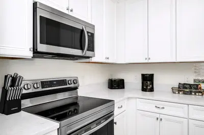a kitchen with a microwave and a stove top oven at Sky Blue Villa Near Disney With Margaritaville Resort & Island H20 Waterpark Access - 3156Cs in Orlando