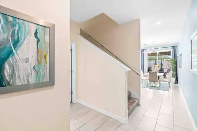 a hallway with a painting on the wall and a dining room at SUPER DOPE- Home w POOL & AMENITIEs in Kissimmee