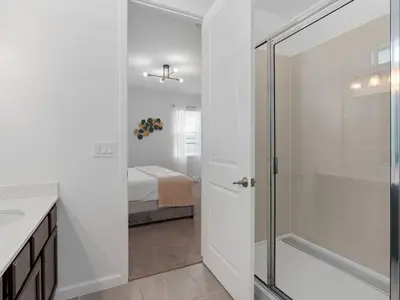 a bathroom with a walk in shower next to a bedroom at SUPER SPACE - 12BD 12BA - MANY ENSUITEs SLEEPs 38 in Kissimmee