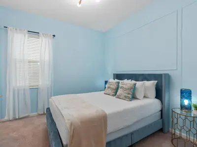 a blue bedroom with a bed with pillows at SUPER SPACE - 12BD 12BA - MANY ENSUITEs SLEEPs 38 in Kissimmee