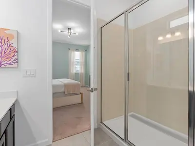 a glass shower door in a bathroom with a bedroom at SUPER SPACE - 12BD 12BA - MANY ENSUITEs SLEEPs 38 in Kissimmee