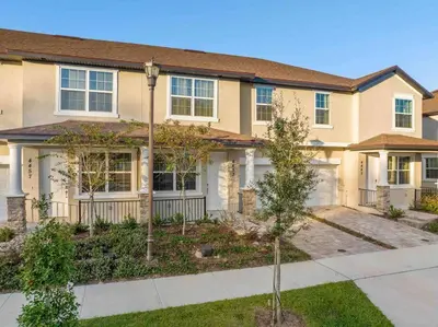 a large house with a sidewalk in front of it at SUPER EPIC- SLEEPs 32 TWO Separate Townhomes in Kissimmee