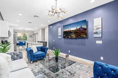 a living room with a blue wall with a couch and a table at SUPER EPIC- SLEEPs 32 TWO Separate Townhomes in Kissimmee