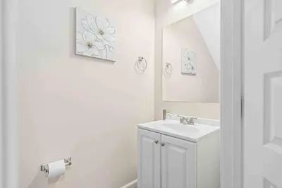 a white bathroom with a sink and a mirror at SUPER POSH- SLEEPs 16 wDESIGNs & NEAR Disney in Kissimmee