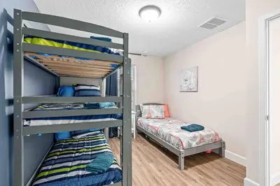 a bedroom with two bunk beds and a bed at SUPER POSH- SLEEPs 16 wDESIGNs & NEAR Disney in Kissimmee