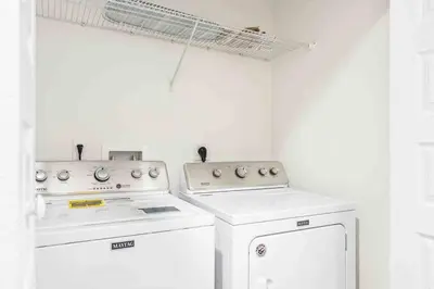 a kitchen with two white appliances and a window at SUPER POSH- SLEEPs 16 wDESIGNs & NEAR Disney in Kissimmee