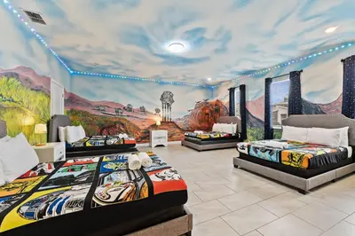 three beds in a room with a mural at SUPER BLISS - 9BDR SLEEPs 30 - MOVIE ROOM & POOL in Kissimmee