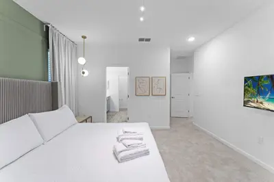 a white bedroom with a bed with towels on it at SUPER CIELO - 12BDR 11BAs - FUN THEME w POOL in Orlando