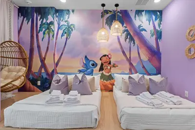 a room with two beds with a painting on the wall at SUPER CIELO - 12BDR 11BAs - FUN THEME w POOL in Orlando
