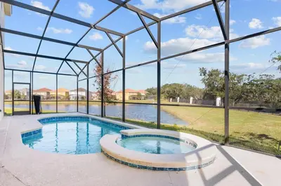a swimming pool in a glass house with a pond at SUPER GIANT - 12BD 12BAs - SLEEP 38 & NEAR DiSNEY in Kissimmee