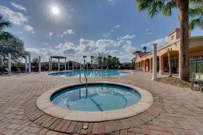 a swimming pool in a brick road with palm trees at 7 Mi to USTA Waterfront Tennis House with Yard! in Kissimmee