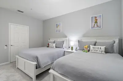 two beds in a bedroom with white walls at Cw7671-205 3Br Condo in Orlando