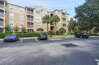 a parking lot with cars parked in front of a building at Cw7671-205 3Br Condo in Orlando