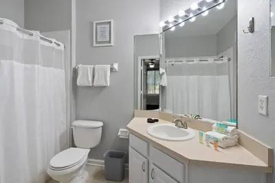a bathroom with a toilet and a sink and a mirror at Cw7671-205 3Br Condo in Orlando
