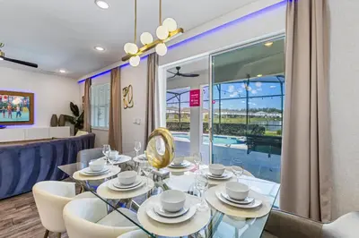 a dining room with a glass table and white chairs at 295 Marcello Blvd in Kissimmee