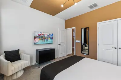 a bedroom with a bed and a chair and a tv at 295 Marcello Blvd in Kissimmee