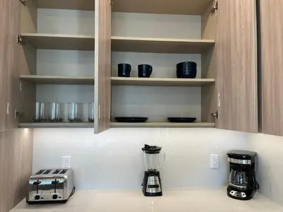 a kitchen counter with bowls and appliances on shelves at Serenity Townhome Getaway 4 bed 3 bath home near Disney in Clermont FL in Orlando