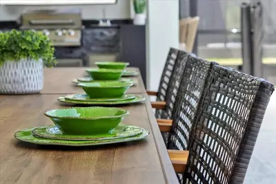 three green bowls on a wooden table with chairs at Gorgeous Paradiso Mansion Pool-Game-Room-Theater-3 in Orlando