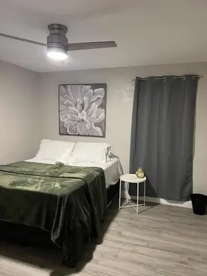 a bedroom with a bed and a flower painting on the wall at City and Stadium Sanctuary Vibes in Orlando