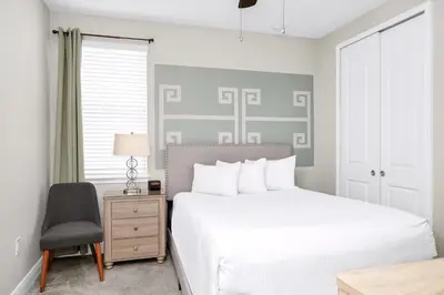 a bedroom with a bed and a desk and a chair at Home With Splash Pad And Slide, Movie Theater & Game Room With Waterpark & Resort Access - 417Sf in Kissimmee