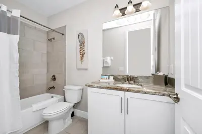 a white bathroom with a toilet and a sink at Home With Splash Pad And Slide, Movie Theater & Game Room With Waterpark & Resort Access - 417Sf in Kissimmee