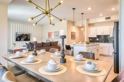 a dining room and living room with a table and chairs at Apartamento Moderno 2Q | Quarto Temático do Mickey in Kissimmee
