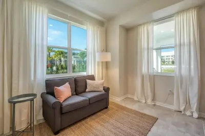 a living room with a couch and two windows at Apartamento Moderno 2Q | Quarto Temático do Mickey in Kissimmee