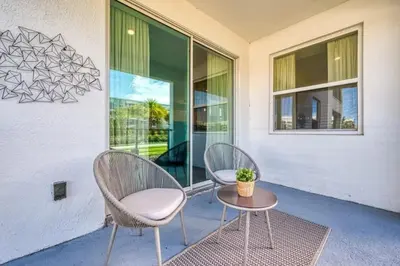 two chairs and a table on a patio at Apartamento Moderno 2Q | Quarto Temático do Mickey in Kissimmee