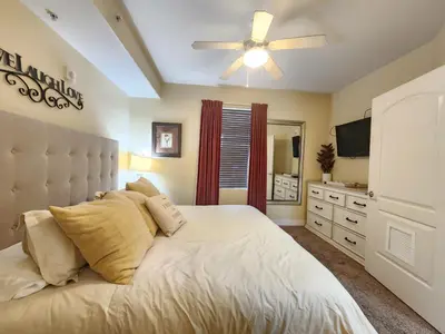 a bedroom with a large white bed with a ceiling fan at Orlando 1st Floor - 5 min Disney in Orlando