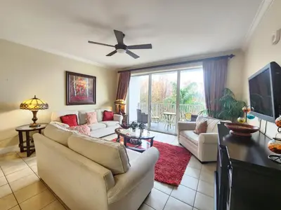 a living room with couches and a flat screen tv at Orlando 1st Floor - 5 min Disney in Orlando