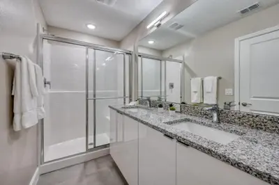 a white bathroom with two sinks and a shower at 7984-Formosa Valley Resort – Vila Luxuosa Perto da Disney (Piscina Aquecida & Quartos Temáticos!) in Orlando