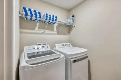 a small laundry room with a washer and dryer at 7984-Formosa Valley Resort – Vila Luxuosa Perto da Disney (Piscina Aquecida & Quartos Temáticos!) in Orlando