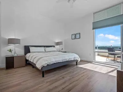 a white bedroom with a bed and a large window at PentHouse Downtown Orlando 2 Beds 2 baths in Orlando