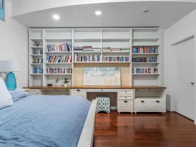 a bedroom with a bed and a desk and bookshelves at PentHouse Downtown Orlando 2 Beds 2 baths in Orlando
